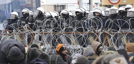 Polnische Polizisten schotten die Grenze nach Belarus gegen Flüc...