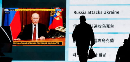 Passanten in Tokio verfolgen die TV-Ansprache Putins (24.2.2022)