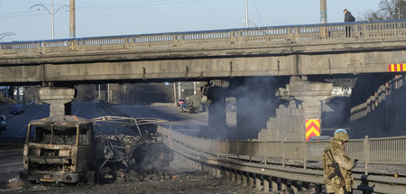 Ukrainische Soldaten inspizieren einen ausgebrannten Truck in Ki...