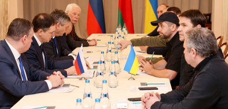 Die russische (l.) und die ukrainische Delegation am Montag an d...