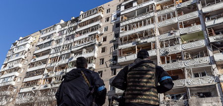 Ukrainische Einsatzkräfte vor einem beschossenen Haus in Kiew am...