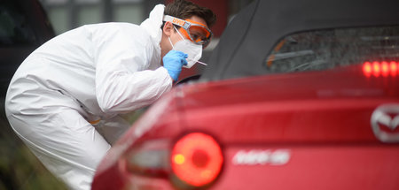 Entnahme eines Abstrichs für einen PCR-Test vor einer Arztpraxis...