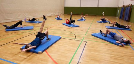 Schüler trainieren mit Mund-Nasen-Schutz in der Sporthalle des J...