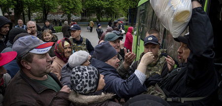 Ein ukrainischer Polizist verteilt Ende April Lebensmittel an Ei