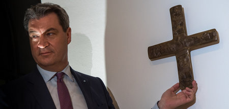 Markus Söder vor einem Kreuz im Eingangsbereich der bayerischen