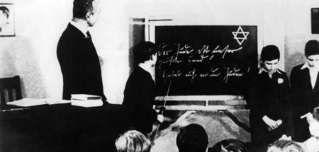Zwei jüdische Jungen vor ihrer Klasse. Auf der Tafel steht zum D...