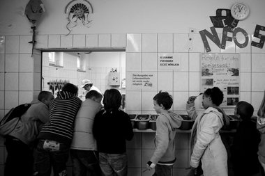 Schlangestehen für ein warmes Mittagessen. Kinder im November 20...