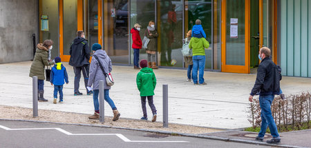 Eltern und Kinder kommen zur Maskenausgabe an einer Grundschule ... Eltern und Kinder kommen zur Maskenausgabe an einer Grundschule ...