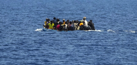 Migranten treiben in einem überfüllten Boot über das Mittelmeer ...
