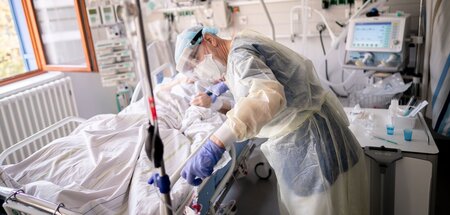 Ein Krankenpfleger auf der Intensivstation einer Klinik bei eine...