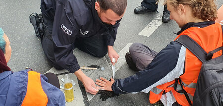 Polizist löst festgeklebten Aktivisten der »Letzten Generation« ...