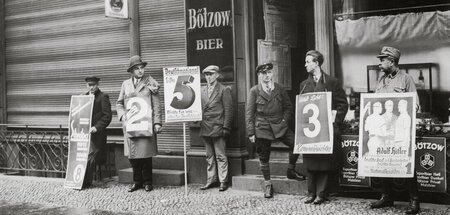 Erneut zur Stimmabgabe aufgerufen. Parteienvertreter vor einem B...