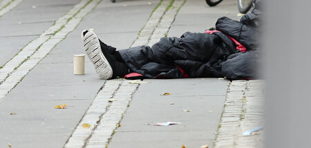 Ein Mann sitzt in einen Schlafsack gehüllt in der Kieler Innenst... Ein Mann sitzt in einen Schlafsack gehüllt in der Kieler Innenst...