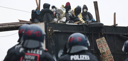 Polizei vor einer von Klimaschutzaktivisten besetzten Barrikade ...