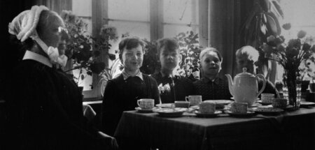 Fröhliche Gesichter unter strenger Aufsicht: Kinder in einer wes...