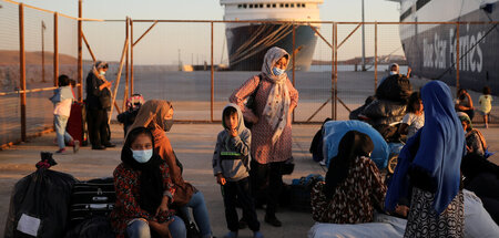 Aus Lagern auf Lesbos kommende Flüchtlinge warten am Hafen von L...