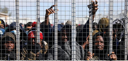 Sollen »regulär« einreisen: Migranten am Zaun eines Geflüchteten...