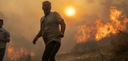 Einheimischer flieht vor den Flammen im Dorf Gennadi auf der Ins...