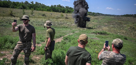 Soldaten der ukrainischen Armee machen Fotos von einer Explosion...