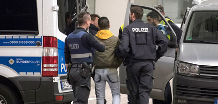 Junger Mann aus Afghanistan in Hand- und Fußfesseln, den Polizis... Junger Mann aus Afghanistan in Hand- und Fußfesseln, den Polizis...