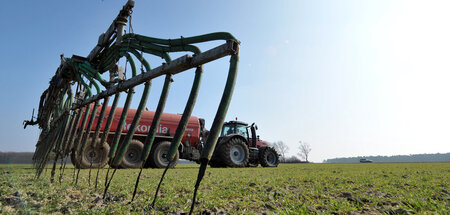Nahrung und Nitratbelastung: Ein Landwirt verteilt Gülle auf ein...