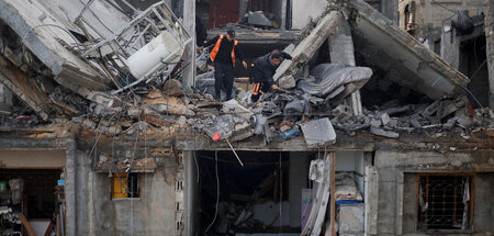 Durchsuchen die Trümmer nach Bombenopfern, bis eine Verhandlungs...