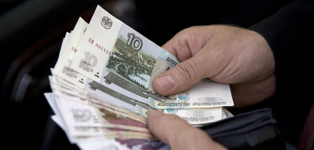 Flüssig, nicht eingefroren: Ein Mann zählt in Moskau Rubel-Schei...