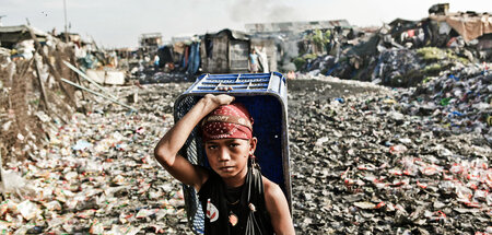 Junge sammelt Plastemüll auf den Philippinen