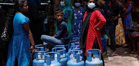 »Im Kontext der Umschuldung«: Wartende mit Gasflaschen in Colomb...