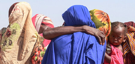 Geflüchtete Frauen aus Darfur erhalten Nachricht von den Hinterb...