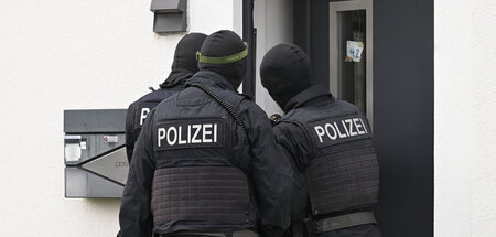 Polizisten durchsuchen im Rahmen der Razzia gegen das Netzwerk e
