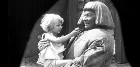 Das Mädchen (Loni Nest) reicht dem Golem (Paul Wegener) den Vers...
