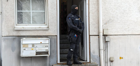 Offenbar häufig überlastet: Polizist im Hauseingang eines durchs...