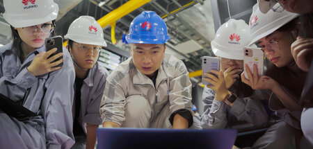 Neue Mitarbeiter von Huawei in China gehen durch ein anstrengend...