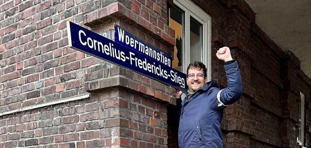 Rachid Messaoudi bringt symbolisch das Straßenschild zu Ehren vo...