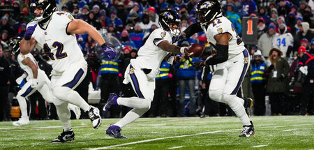 Lamar Jackson (M.) gibt seinem Runningback Derrick Henry den Bal...