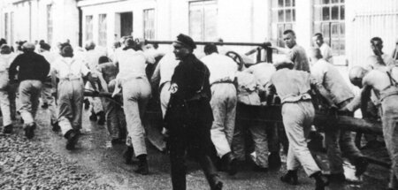 Gefangene werden im KZ Dachau zur Zwangsarbeit getrieben (1933)