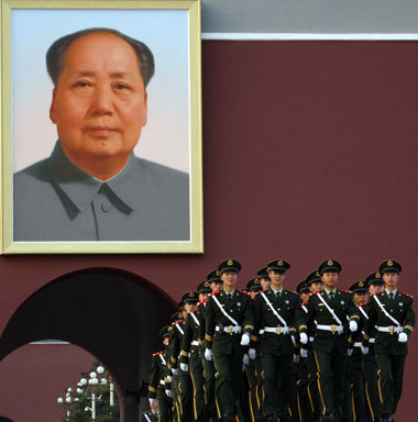 Polizisten vor einem Porträt Mao Tse-tungs bei einer Flaggenzere...