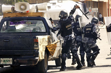 Polizisten prügeln in San Pedro Sula auf einen Lautsprecherwagen...