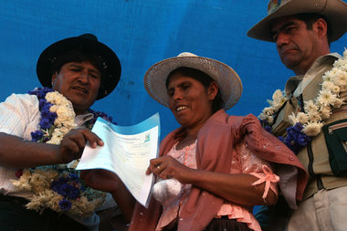 Evo Morales händigt einer Bäuerin die Urkunde über ihren Landbes...
