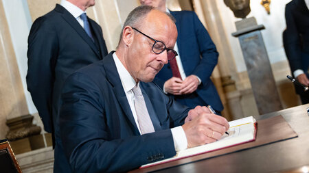 Friedrich Merz trägt sich ins Goldene Buch des Übersee-Clubs ein...