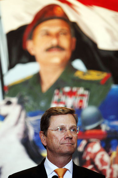 Westerwelle vor einem Wandbild des jemenitischen Präsidenten am ...