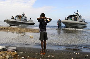 Ein haitianischer Junge beobachtet Landungsboote der US Navy am ...