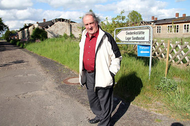 Der 77jährige Ivar Buterfas vor zerfallenen Lagerbaracken
