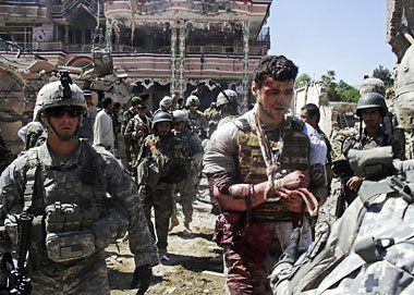 US-Soldaten begleiten einen verwundeten DAI-Angestellten aus
dem...