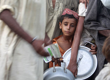 Spärliche Hilfen: Pakistanisches Kind wartet an einer Ausgabeste... Spärliche Hilfen: Pakistanisches Kind wartet an einer Ausgabeste...
