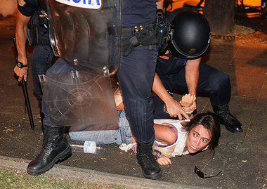 Eine junge Frau im Griff der Polizei. Die spanische Tageszeitung... Eine junge Frau im Griff der Polizei. Die spanische Tageszeitung...
