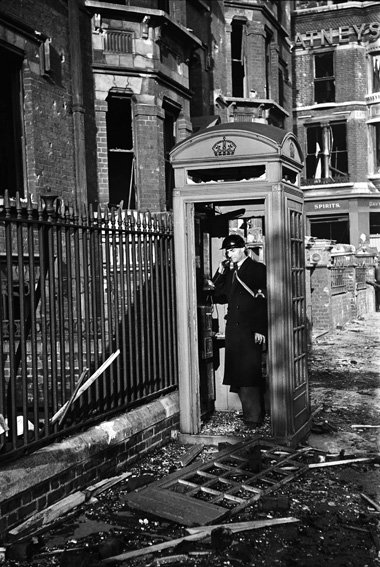 London 1940: Ein Luftschutzwart telefoniert nach einem deutschen...