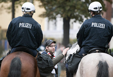 Hamburg im November. Demonstrant streichelt Pferd. Kritik an Rei...