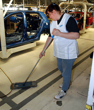 Putzfrau wischt den Boden im VW-Werk Zwickau-Mosel